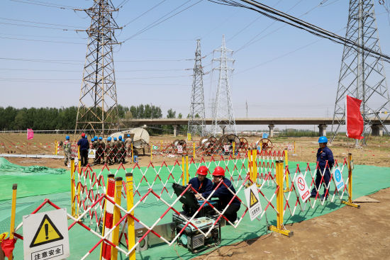 5月11日,在66千伏孙家-航辽线路改造工程现场,国网沈阳供电公司施工人员应用可视化牵张机智能设备开展线路架设作业。 史灵丰 摄 5月11日,在66千伏孙家-航辽线路改造工程现场,国网沈阳供电公司施工人员应用可视化牵张机智能设备开展线路架设作业。 史灵丰 摄