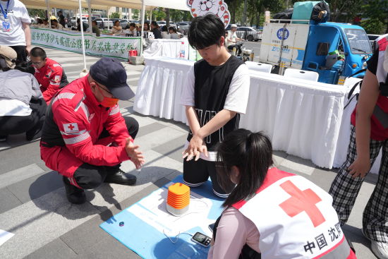 沈阳市红十字会志愿者教授儿童CPR与海姆立克急救法。韩浩天 摄 沈阳市红十字会志愿者教授儿童CPR与海姆立克急救法。韩浩天 摄