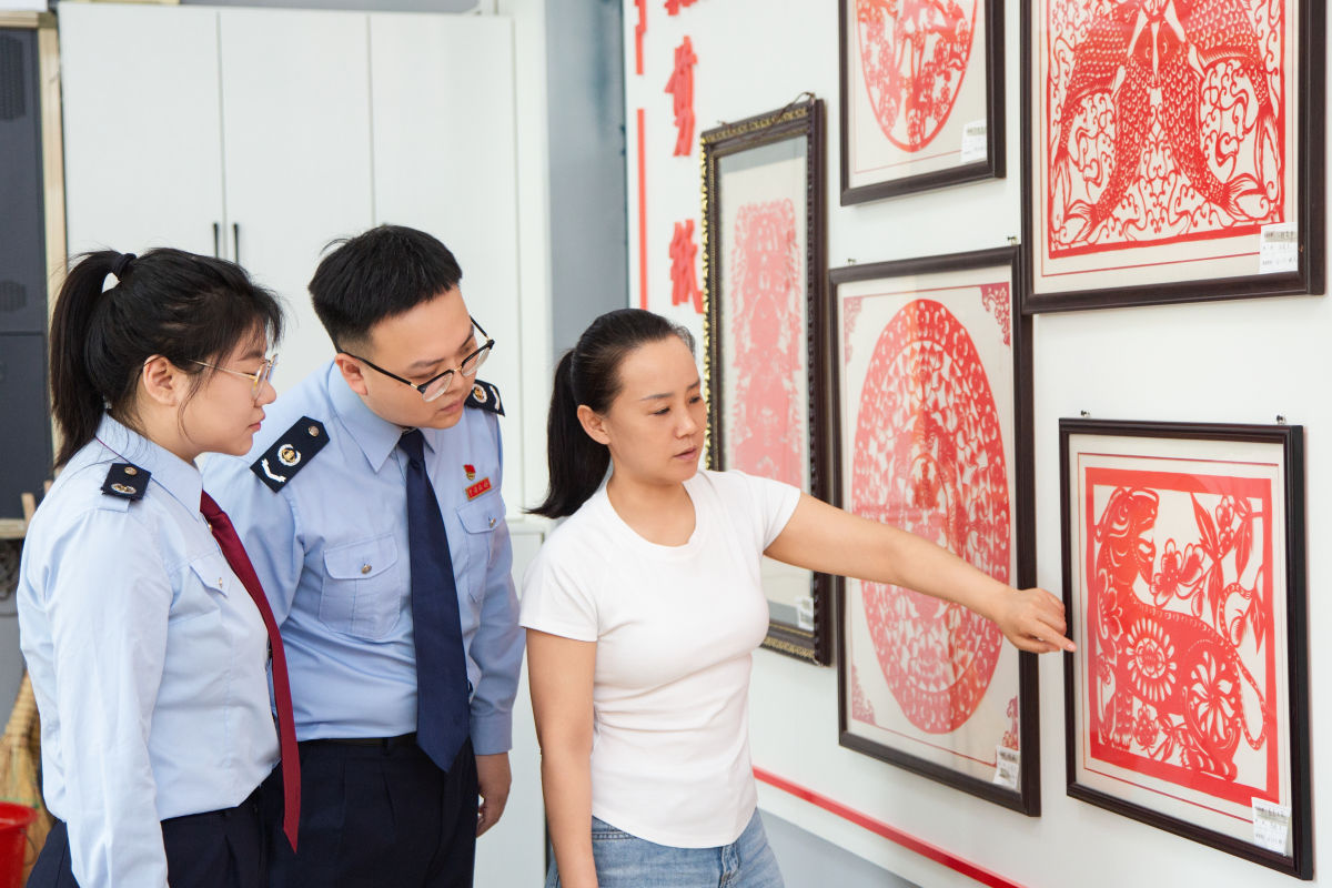 图为“非遗”传承人马晓东为税务干部介绍满族剪纸的基本情况。刘振廷 覃文博摄 图为“非遗”传承人马晓东为税务干部介绍满族剪纸的基本情况。刘振廷 覃文博摄