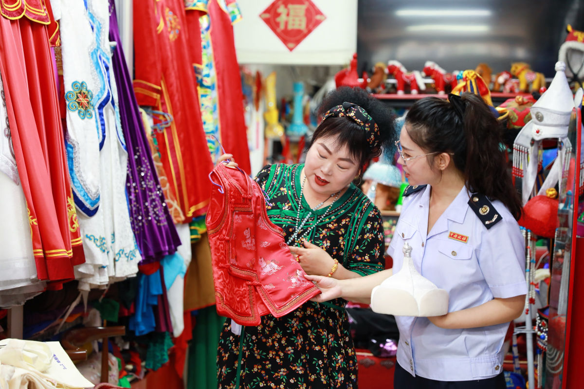 图为税务干部试穿蒙古勒津“非遗”服饰表演装。满大千 刘美辰摄 图为税务干部试穿蒙古勒津“非遗”服饰表演装。满大千 刘美辰摄