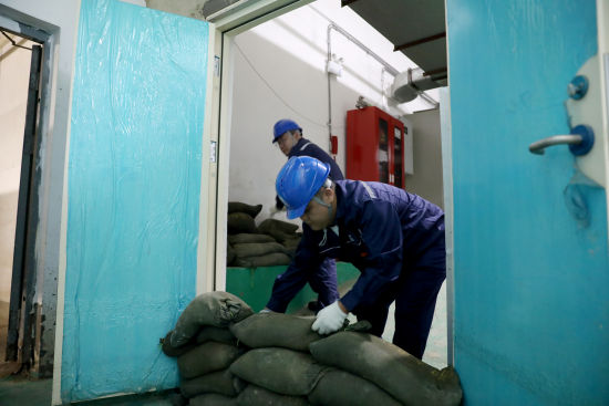 国网沈阳供电公司配电运检人员在地下配电室出入口堆砌防汛沙袋,做好低洼配电房防水封堵。 史灵丰 摄 国网沈阳供电公司配电运检人员在地下配电室出入口堆砌防汛沙袋,做好低洼配电房防水封堵。 史灵丰 摄